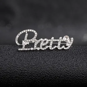 Macro shot of silver-tone Pretty letter brooch with sparkling rhinestones and pear-cut gem