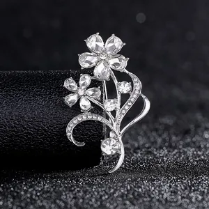 Detail einer silbernen Blumenbrosche mit funkelnden Zirkonia auf schwarzem Leder