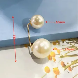 Dettaglio della spilla a doppia perla dorata da 36mm con perle bianche da 12mm e 16mm