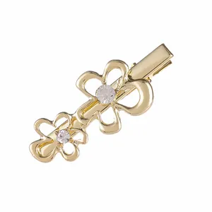 Elegant gold flower hair clip with sparkling rhinestones on a minimalist metal duckbill base