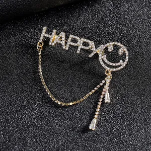 Luxury gold brooch featuring HAPPY letters, crystal smiley face and tassel chain