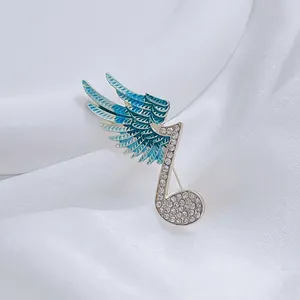 Detail of music note brooch with crystal pavé and blue enamel butterfly wings