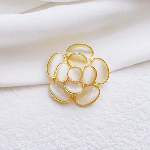 Elegante broche de camelia con pétalos de piedra ojo de gato en base de metal dorado