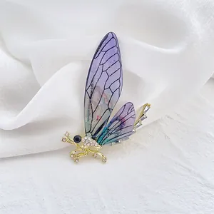 Macro view of cicada brooch with purple gradient wings and sparkling rhinestones