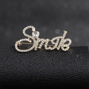 Macro detail of Smile alphabet brooch with sparkling heart crystal and rhinestones