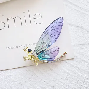 Macro detail of a dragonfly brooch with gradient purple wings and crystal accents