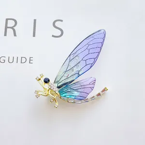 Detail of dragonfly brooch with purple gradient wings and sparkling rhinestones