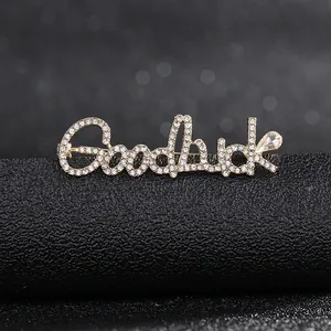 Macro shot of Goodluck letter brooch with sparkling rhinestones and teardrop crystal