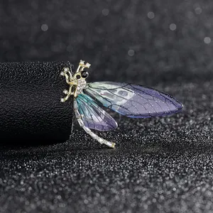 Macro detail of a dragonfly brooch with blue-purple wings and micro-pave zircons
