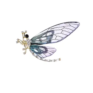 Detailed shot of insect brooch featuring purple gradient wings and sparkling rhinestones