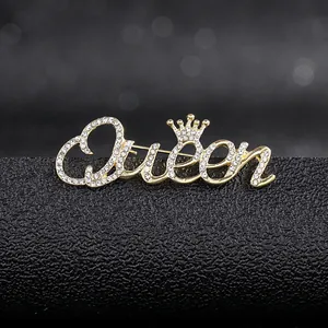 Macro detail of a golden Queen brooch with sparkling crystals and a crown detail