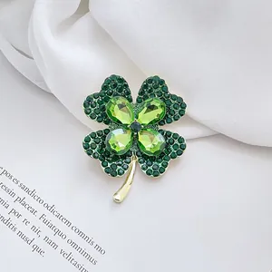 Exquisite gold four-leaf clover brooch with green rhinestones on silk and magazine