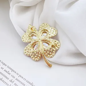 Back view of elegant gold-plated four-leaf clover brooch with sparkling rhinestones