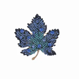 Eleganter Ahornblatt-Anstecker mit blau-grünen Strasssteinen auf vergoldeter Metallbasis