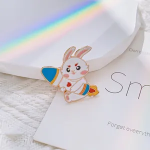Détail d'un pin's émaillé en forme de lapin mignon sur une fusée colorée sur tissu blanc