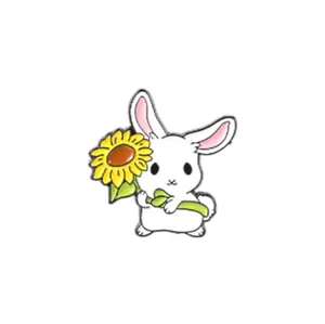 Détail d'une broche en émail représentant un lapin mignon tenant un tournesol jaune vif