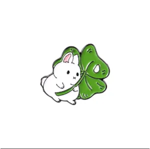 Détail du pin's émaillé lapin blanc mignon tenant une feuille de monstera verte