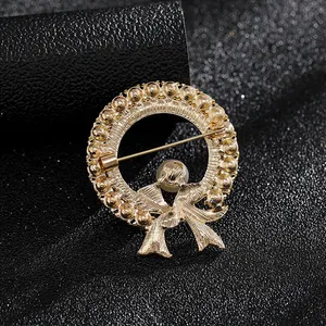 Elegante broche de corona dorada con perla y lazo, vista posterior del cierre de pasador