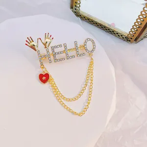 Broche dorado HELLO con pedrería de cristal, colgante de corazón rojo y elegantes cadenas