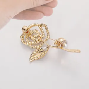 Élégante broche fleur rose dorée avec perle blanche et vue sur l'attache arrière