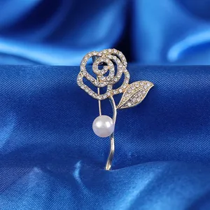 Broche rose dorée de luxe avec cristaux et perle élégante sur fond de soie bleue