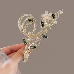 Detail of tulip tassel hair claw with gold alloy branch, white pearls and rhinestones
