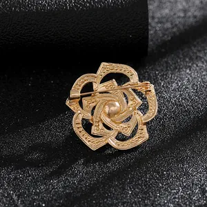 Detalle macro del reverso del broche de flor dorada con el cierre de alfiler y textura