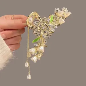Detailed view of tulip tassel claw clip with rhinestones, pearls and floral enamel
