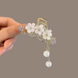 Detailed view of tulip hair claw clip with rhinestones and hanging pearl tassels