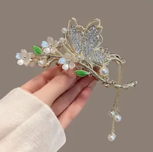 Detail of tulip hair claw clip with rhinestones, blue petals and long pearl tassels
