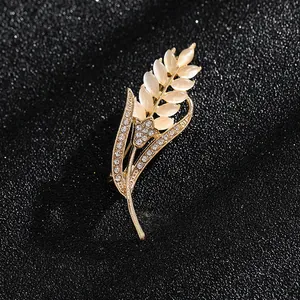 Detalle de broche de trigo dorado con piedras de opales y pedrería brillante de lujo