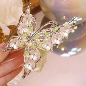 Detail of butterfly hair claw with pearls, rhinestones and shell flowers on gold alloy