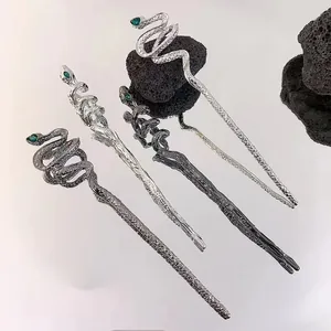 Detailed view of snake hairpins in four metallic finishes with green gem eyes