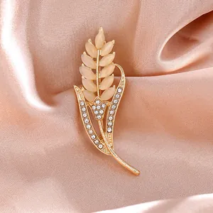 Detalle de broche de espiga de trigo con piedras ojo de gato champán y cristales