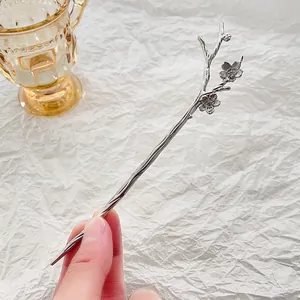 Macro detail of silver plum blossom hair stick with vintage wood grain texture