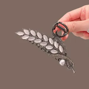 Detail of tulip tassel hair claw clip featuring gunmetal finish and opal leaf accents