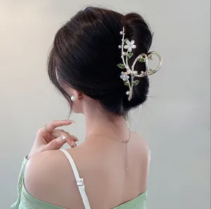Detail of tulip hair claw clip with tassels and rhinestones worn on a low bun hair