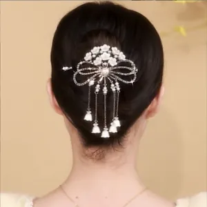 Rear view of a model wearing a tulip tassel hair claw with white flowers and pearls