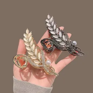 Elegant gold and black leaf hair claws with marquise opals and sparkling rhinestones