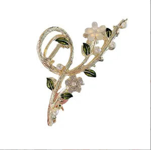Elegant gold tulip hair claw with white pearls, rhinestones, and green enamel leaves