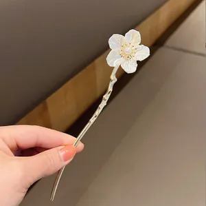 Détail de l'épingle à cheveux muguet avec perles et tige dorée en forme de vague