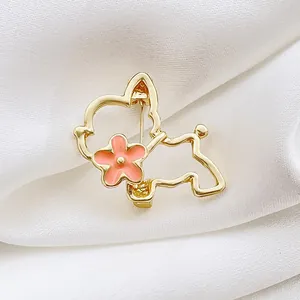 Broche de perro dorado calado con flor rosa sobre elegante tela de satén blanco