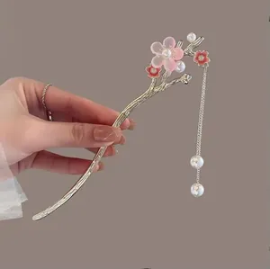Détail d'une épingle à cheveux muguet avec pétales roses et glands en perles