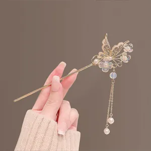Détail d'épingle à cheveux papillon vintage avec pompons et perles sur fond beige