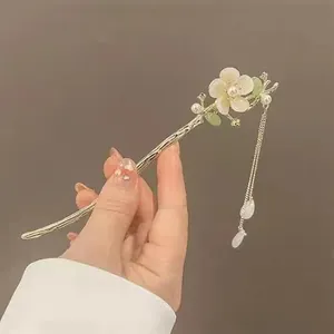 Gros plan détaillé d'une épingle à cheveux rétro avec muguet et glands en soie
