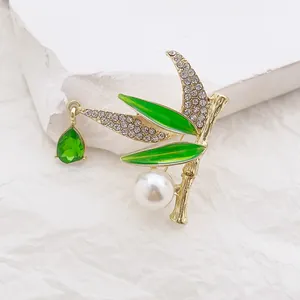 Chinese style bamboo brooch with green enamel, white diamonds, and emerald water drop pendant