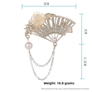 Detail of gold fan-shaped hair clip with rhinestones, rose, pearls and tassel chain