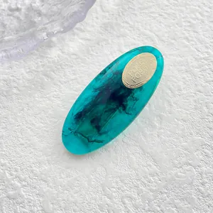 Detalle de pinza para el pelo ovalada de resina verde azulado con textura de mármol