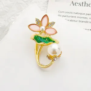 Dettaglio spilla a fiore di loto in lega con petali rosa, smalto verde e perle bianche