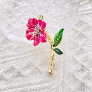 Elegant floral enamel brooch with crystal rhinestones on a textured white fabric background